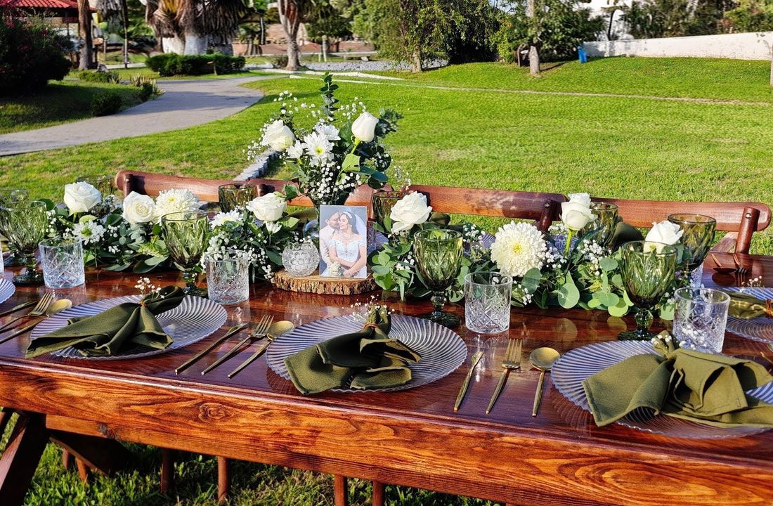 Mesa rectangular de madera preparada para una celebración al aire libre