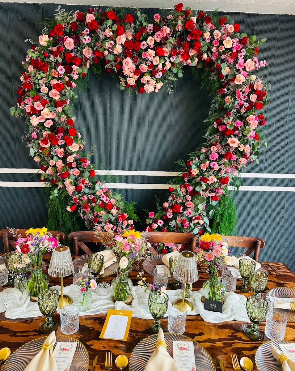 Ambientación floral con mesa de madera preparada para una celebración