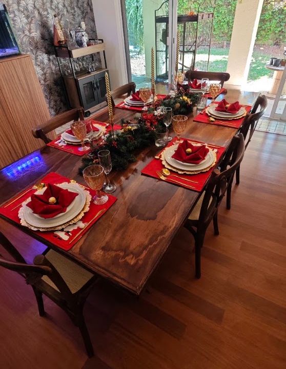 Ambientación interior con mesa, flores rojas y luz natural