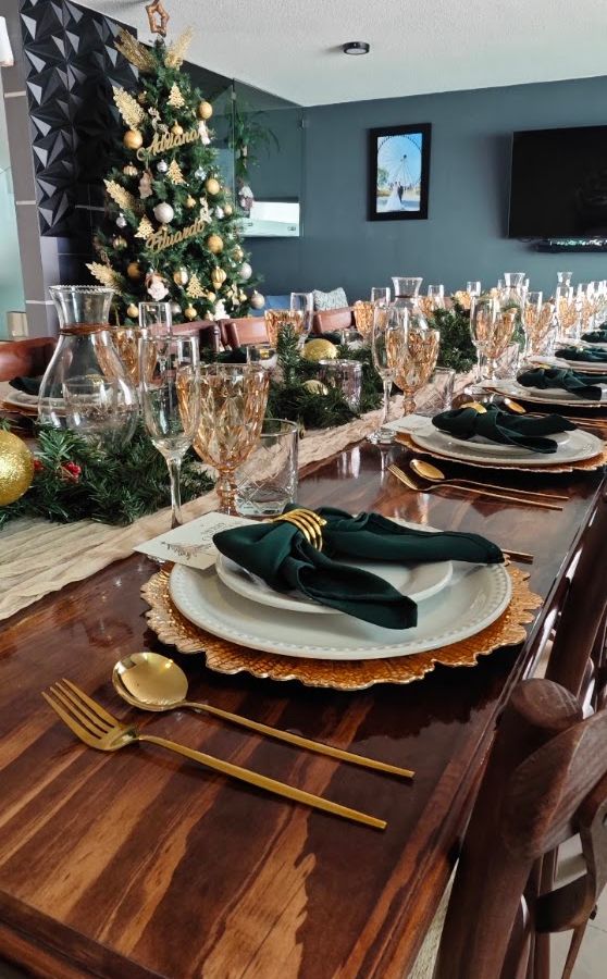Decoración de celebración con follaje, cristalería ámbar y textiles verdes
