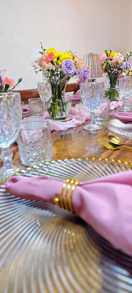 Montaje de mesa en tonos pastel con flores y cristalería