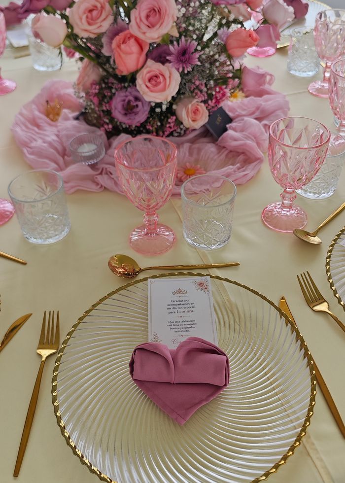 Celebración decorada con flores rosas, lilas y vajilla dorada