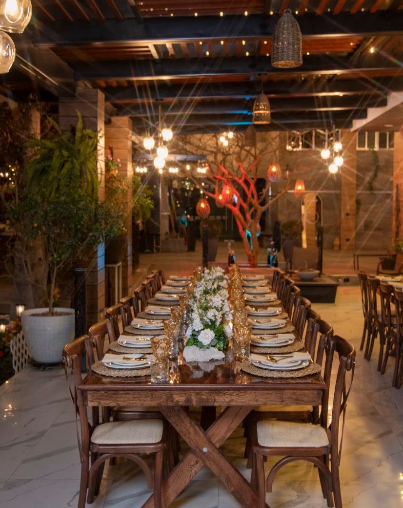 Mesa rectangular de madera con sillas crossback preparada para una celebración